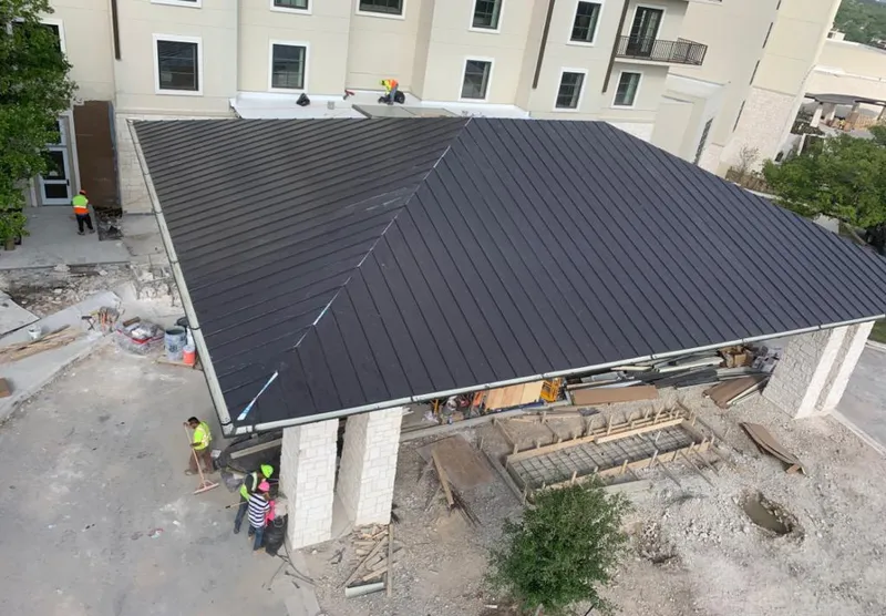Metal roofing installation team working on a commercial building in Orange